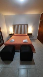 1 dormitorio con 1 cama grande de color naranja y 2 sillas en Nieva 4M en San Salvador de Jujuy