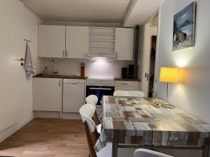 - une cuisine avec une table en bois et des placards blancs dans l'établissement The Atlantic view guest house, Sandavagur, Faroe Islands, à Sandavágur
