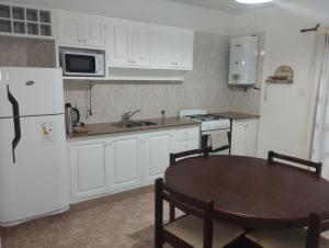 a kitchen with a table and a white refrigerator at Nieva 4M in San Salvador de Jujuy