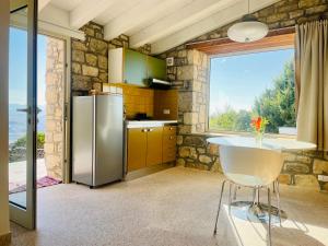 una cucina con frigorifero, tavolo e finestra di LA CASETTA SULLE NUVOLE PETRA a Cammarata