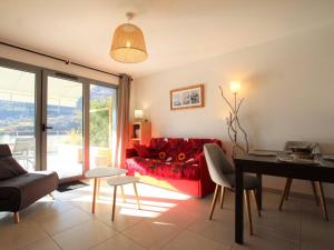 a living room with a red couch and a table at Appartement 3 étoiles, 42m², terrasse ensoleillée, 4 pers., Briançon - FR-1-330C-115 in Briançon