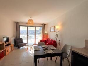 a living room with a table and chairs and a television at Appartement 3 étoiles, 42m², terrasse ensoleillée, 4 pers., Briançon - FR-1-330C-115 in Briançon +7 photos