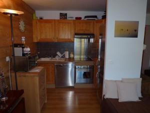a kitchen with wooden cabinets and stainless steel appliances at Appartement Isola 2000, 3 pièces, 6 personnes - FR-1-292-153 in Isola 2000