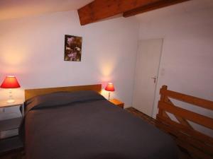 ein Schlafzimmer mit einem Bett, zwei Lampen und einer Tür in der Unterkunft Studio Bagnères-de-Luchon, 1 pièce, 4 personnes - FR-1-313-124 in Luchon