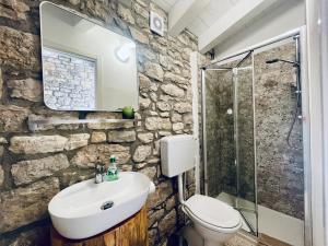 a stone bathroom with a sink and a shower at LA CASETTA SULLE NUVOLE PETRA in Cammarata