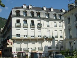 a large white building with balconies on a street at Appartement Bagnères-de-Luchon, 3 pièces, 6 personnes - FR-1-313-150 in Luchon