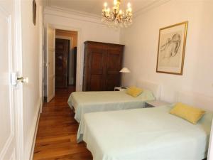 a room with two beds and a chandelier at Grand T2 Ensoleillé à Luchon, Face aux Thermes, pour 4 Pers., Proche Télécabine - FR-1-313-165 in Luchon