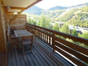 a wooden deck with a table and chairs on it at Appartement Isola 2000, 3 pièces, 6 personnes - FR-1-292-153 in Isola 2000