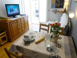a dining room with a table and a television at T2 Calme - Balcon - Parking - Animaux admis - FR-1-313-187 in Luchon +5 photos