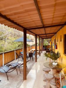 een overdekt terras met tafels en stoelen bij Pousada do Pescador Eli in Fernando de Noronha