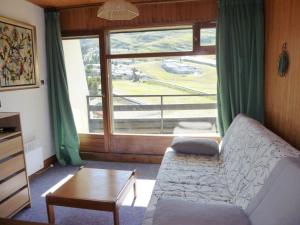 ein Wohnzimmer mit einem Sofa und einem großen Fenster in der Unterkunft Studio Arette, 1 pièce, 4 personnes - FR-1-602-15 in Arette