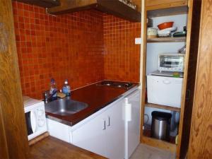 eine kleine Küche mit einer Spüle und einer Mikrowelle in der Unterkunft Studio Arette, 1 pièce, 4 personnes - FR-1-602-15 in Arette