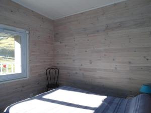 a bedroom with a bed in a wooden wall at Charmant Appartement 3 Pièces à Arette - 2 Chambres, Casiers à Skis, Parkings Gratuits - FR-1-602-26 in Arette