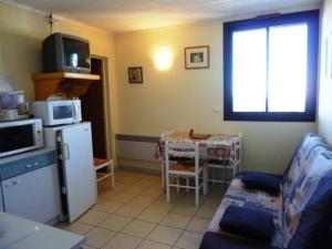 cocina pequeña con mesa pequeña y nevera en Appartement Arette, 2 pièces, 6 personnes - FR-1-602-53, en Arette