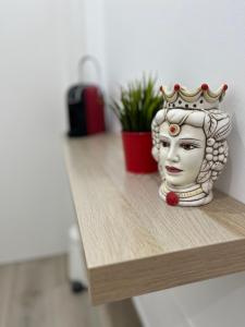 uma estátua de uma cabeça com uma coroa sobre uma mesa em Dimora sicula guest house em Catânia