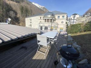 a grill and a table and chairs on a deck at Appartement Barèges, 3 pièces, 6 personnes - FR-1-403-96 in Barèges