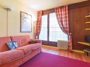 uma sala de estar com um sofá rosa e uma janela em Appartement Montgenèvre, 2 pièces, 6 personnes - FR-1-330D-7 em Montgenèvre
