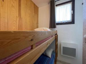 a bunk bed in a room with a wooden wall at Appartement Montgenèvre, 1 pièce, 4 personnes - FR-1-330D-44 in Montgenèvre