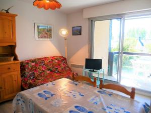 uma sala de estar com uma mesa, um sofá e uma janela em Appartement Quiberon, 2 pièces, 2 personnes - FR-1-478-166 em Quiberon