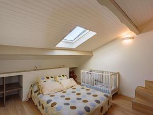 a bedroom with a crib and a skylight at Appartement Saint-Jean-de-Luz, 4 pièces, 6 personnes - FR-1-4-590 in Saint-Jean-de-Luz