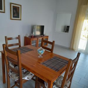 una mesa de madera con sillas y un tazón. en A Casa di Falco, en Mondragone