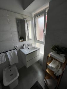 a bathroom with a sink and a toilet and a window at Dimora sicula guest house in Catania