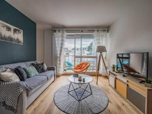 a living room with a couch and a tv at Bénodet : Appartement rénové face mer, 100m de la plage, parking privé, balcon, 3 étoiles, 4 pers. - FR-1-481-80 in Bénodet