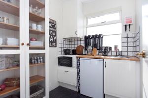 een keuken met een witte koelkast en een wastafel bij Overlooking the city, bright & cozy - Free Parking (A2) in Reykjavík