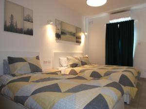 Duas camas sentadas uma ao lado da outra num quarto em Blue Sky Apartments em Mġarr