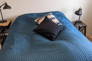a blue bed with a black pillow on it at Modern and Stylish Reykjavik Apartment in Reykjavík