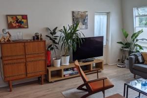 sala de estar con TV de pantalla plana y plantas en Modern and Stylish Reykjavik Apartment, en Reikiavik