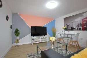 a living room with a flat screen tv and a table at Oasis, Central Self Contained Flat by CozyNest in Reading