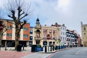 a city street with buildings and a stop sign at Oasis, Central Self Contained Flat by CozyNest in Reading