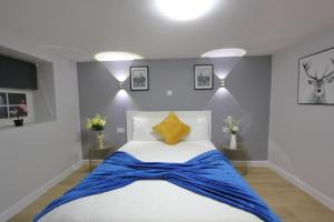 a bedroom with a bed with a blue blanket on it at Oasis, Central Self Contained Flat by CozyNest in Reading