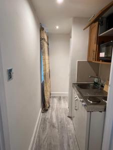 een kleine keuken met een wastafel en een aanrecht bij F4-Ground floor Studio Fits 3 Near Paddington in Londen