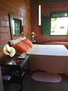 a bedroom with a bed and a brick wall at Fazenda Hotel Serra da Copioba in Sobradinho