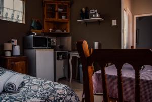 a kitchen with a table and a kitchen with a refrigerator at Farm stay at Thyme Cottage on Haldon Estate in Bloemfontein