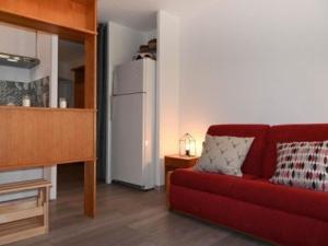 sala de estar con sofá rojo y nevera blanca en Appartement Montgenèvre, 2 pièces, 6 personnes - FR-1-266-161, en Montgenèvre