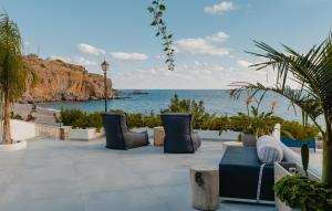 a patio with chairs and a view of the ocean at Blue Paradise in Ierápetra