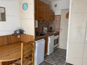 a small kitchen with wooden cabinets and white appliances at Studio Les Angles, 1 pièce, 4 personnes - FR-1-295-181 in Les Angles