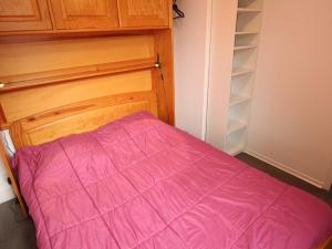 um quarto com uma cama com um cobertor rosa em Appartement Bagnères-de-Luchon, 2 pièces, 4 personnes - FR-1-313-159 em Luchon