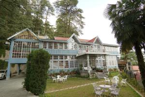 a large building with tables and chairs in front of it at The Edgeworth in Shimla