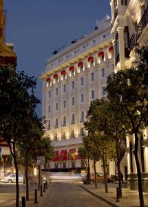 a large white building with trees in front of it at Hotel Colón Gran Meliá - The Leading Hotels of the World in Seville