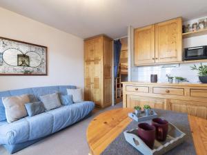 a living room with a blue couch and a wooden table at Studio Saint-Lary-Soulan, 1 pièce, 4 personnes - FR-1-296-316 in Saint-Lary-Soulan