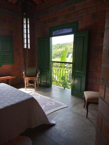 a bedroom with a green door and a balcony at Fazenda Hotel Serra da Copioba in Sobradinho