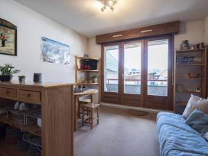 a living room with a couch and a desk and a window at Studio Saint-Lary-Soulan, 1 pièce, 4 personnes - FR-1-296-316 in Saint-Lary-Soulan