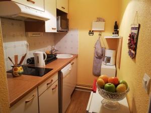 a kitchen with a bowl of fruit on the counter at Appartement 2 pièces cabine avec balcon, parking, animaux admis, Wi-Fi - FR-1-313-195 in Luchon