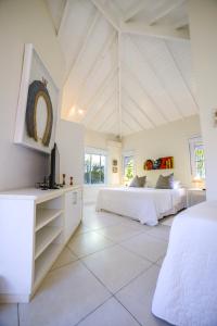 a white room with two beds and a tv at Maris Paraty in Paraty