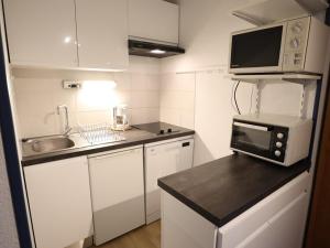 uma pequena cozinha com armários brancos e um micro-ondas em Appartement Arêches-Beaufort, 2 pièces, 5 personnes - FR-1-342-250 em Beaufort