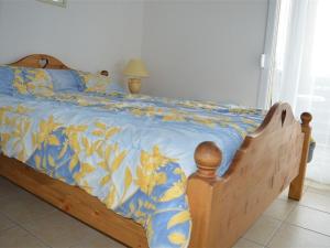 Una cama con una manta azul y amarilla. en Appartement Les Angles, 2 pièces, 4 personnes - FR-1-593-32 en Les Angles